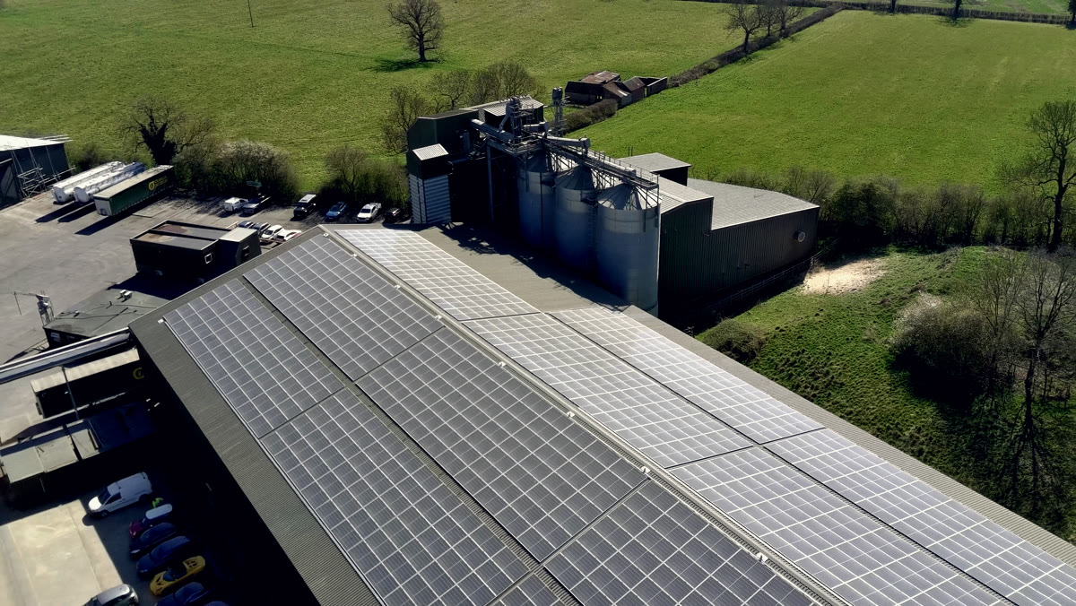 The 417kWp grain-store installation — panelled roofline above the timber yard